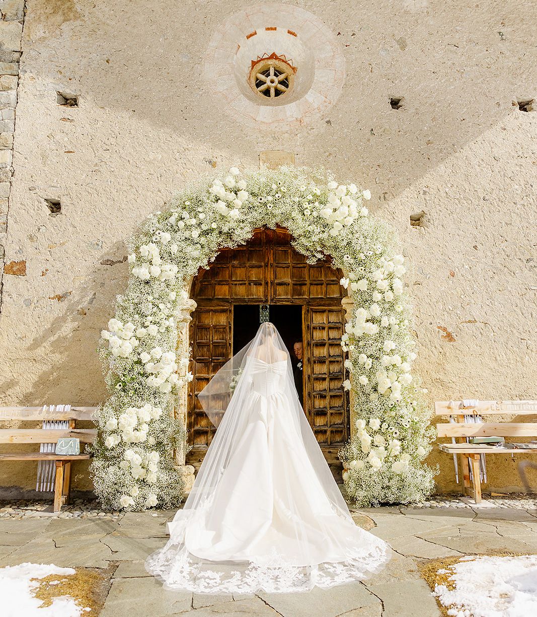 Bride entering the church at old world winter wedding in Saint Moritz