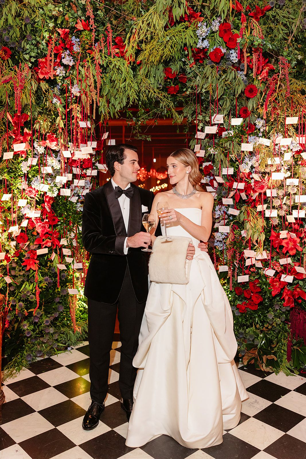 Bride and groom by flower display at the old world winter wedding in Saint Moritz