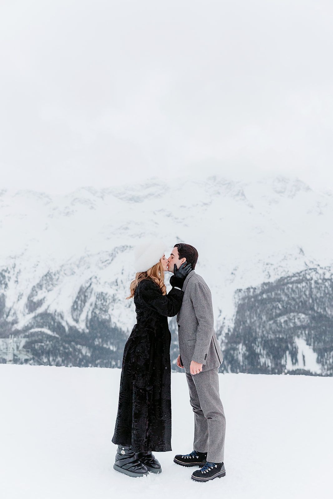 Bride and groom kiss at the welcome dinner of old world winter wedding in Saint Moritz