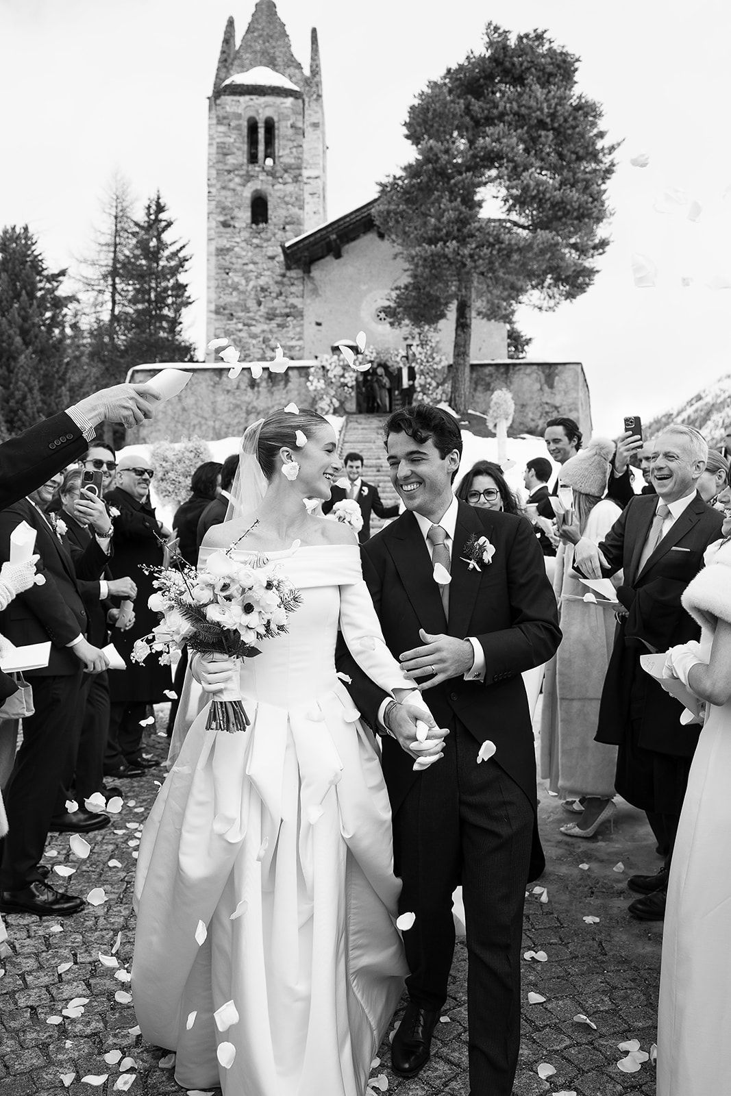 Bride and groom under petal shower at the old world winter wedding in Saint Moritz