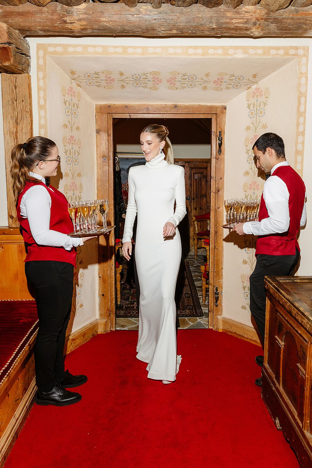 Entrance of the bride with champagne at the rehearsal dinner of old world winter wedding in Saint Moritz