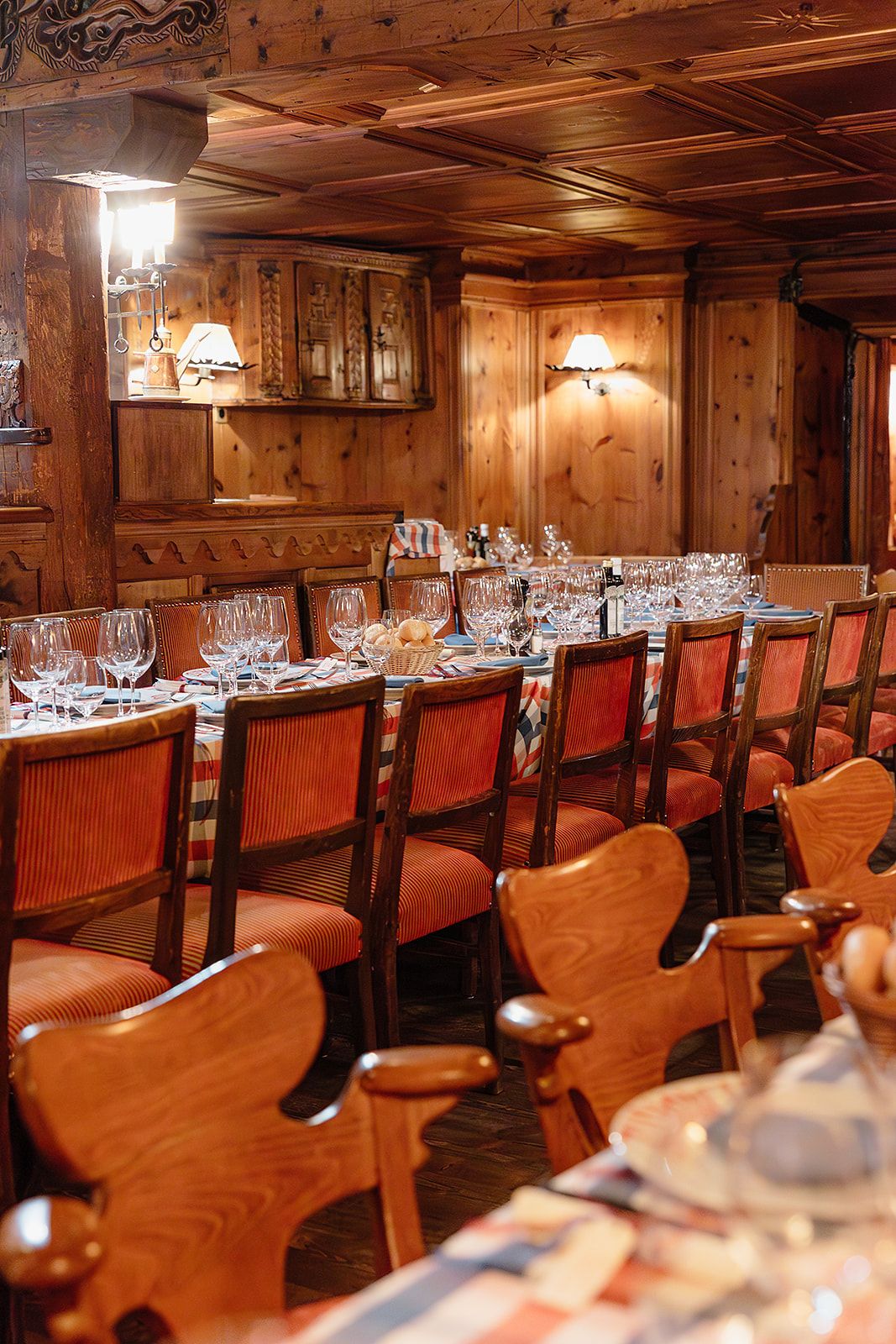 Long tables in the wooden room at the rehearsal dinner of old world winter wedding in Saint Moritz